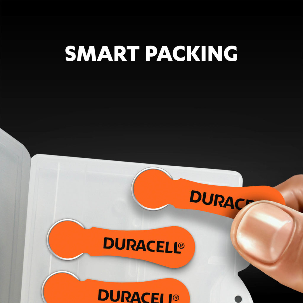 Fingers holding the hearing aids batteries from a package
